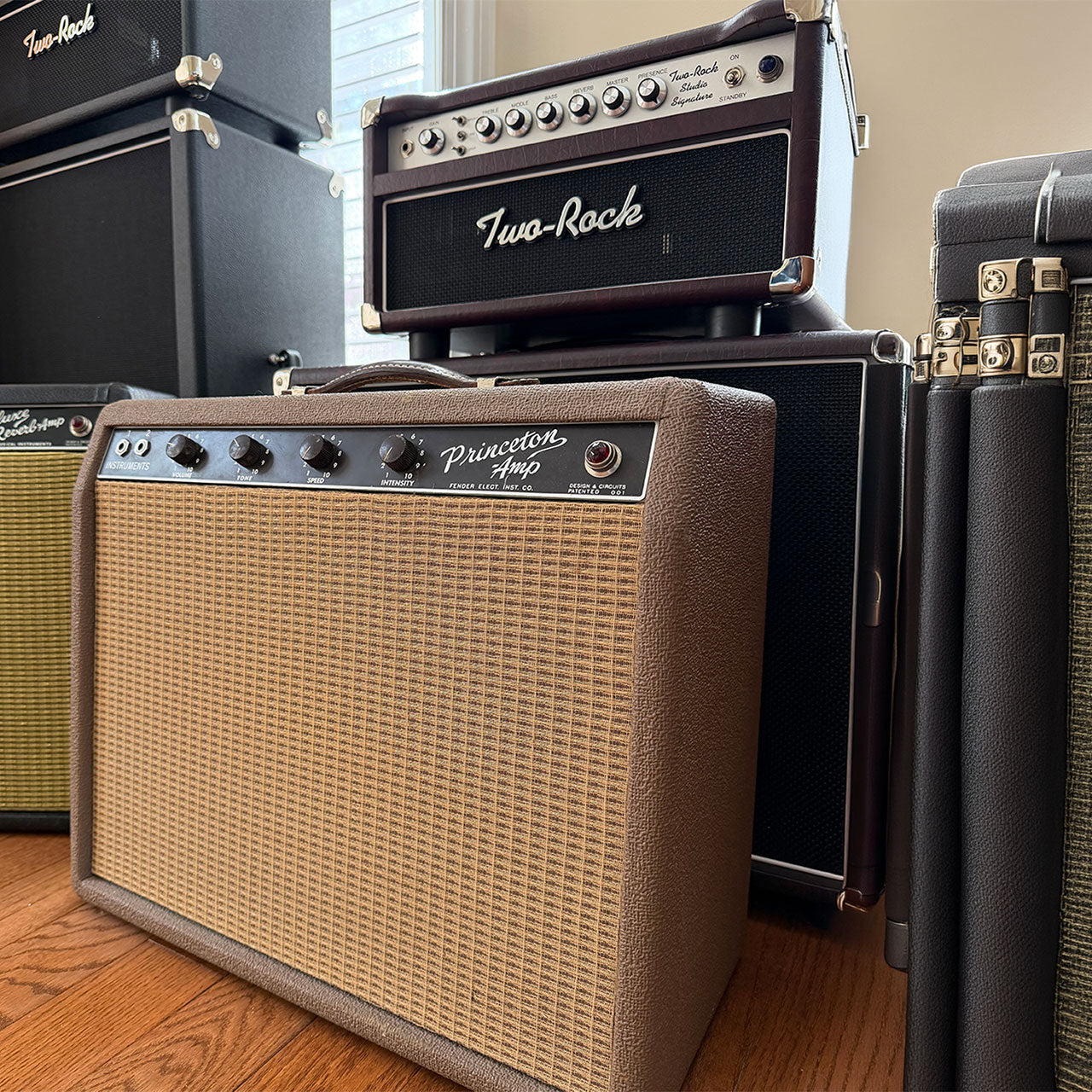 Collection of guitar amplifiers with 'Two-Rock' branding on a wooden floor.
